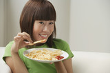Young woman eating a plate of French fries