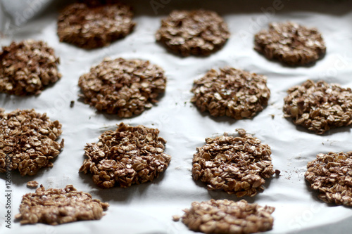 Simple cookies prepared with three ingredients: oatmeal, mashed bananas and cocoa powder, before baking. Top view, selective focus.
