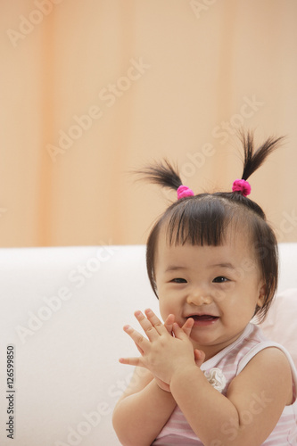 Baby Girl clapping hands and laughing, looking at camera