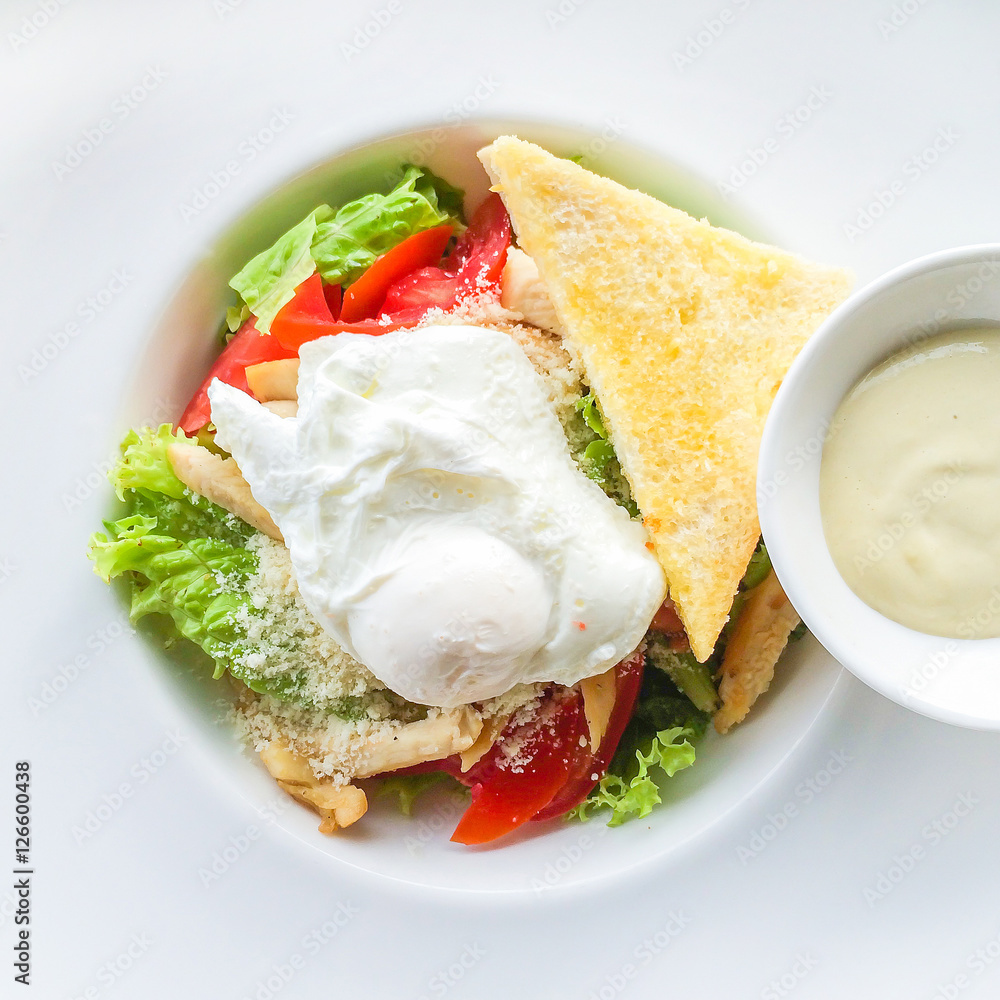 Delicious caesar salad, with baby kos lettuce leaves, bacon bits, toasted baguette, a poached egg, shaved parmesan, and a creamy dressing.