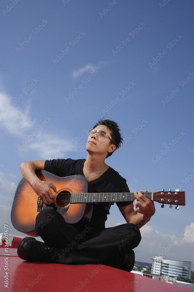 Man playing guitar outdoors