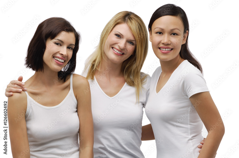 Three young woman wearing white shirts and smiling at camera Three young woman wearing white shirts and smiling at camera
