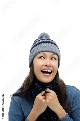 Young woman wearing winter hat and scarf, smiling and looking up