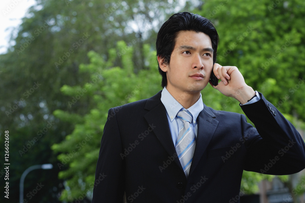 A man wearing a suit talks on his cellphone A man wearing a suit talks on his cellphone