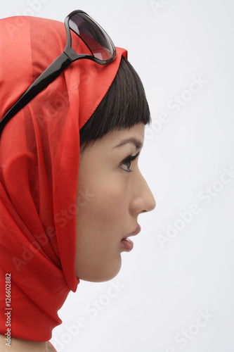 Profile of woman wearing red scarf and sunglasses