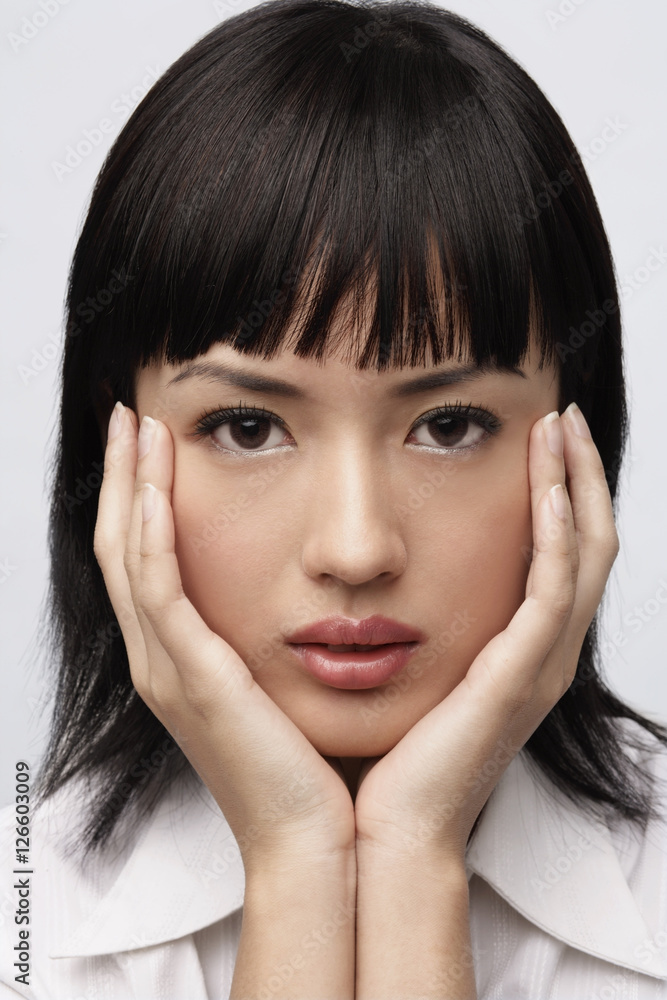 Portrait of woman with hands on face