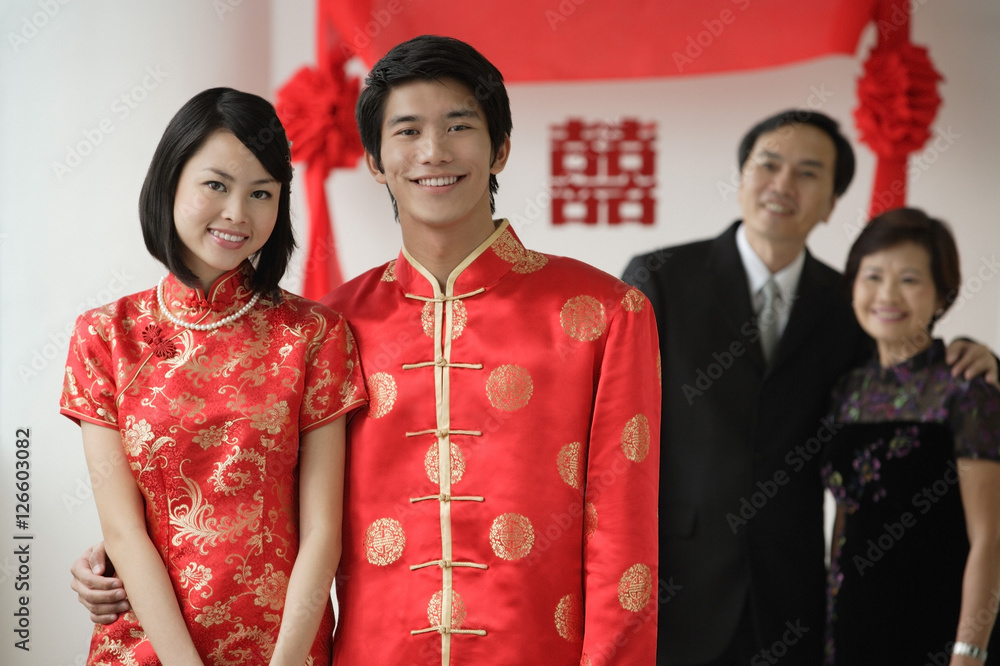 A newlywed couple and their family smile at the camera together