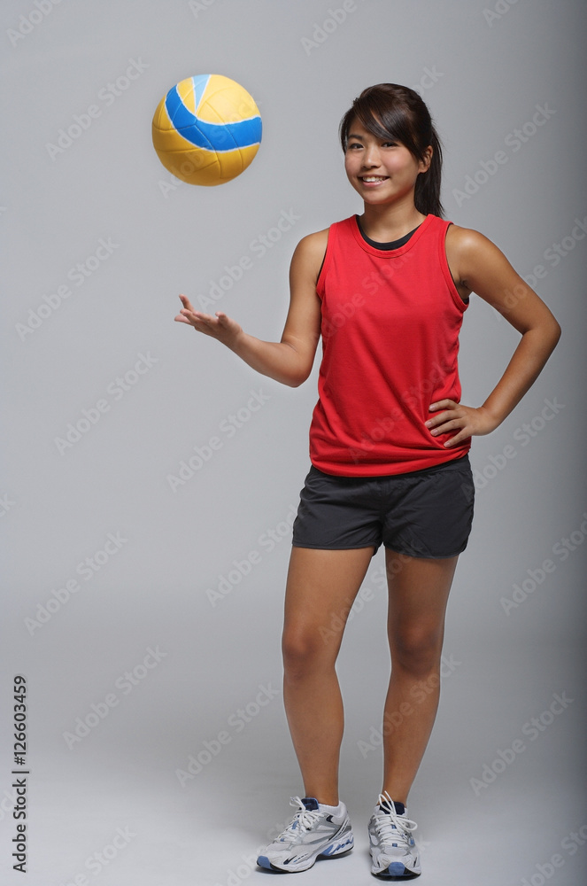 Young woman playing with volleyball