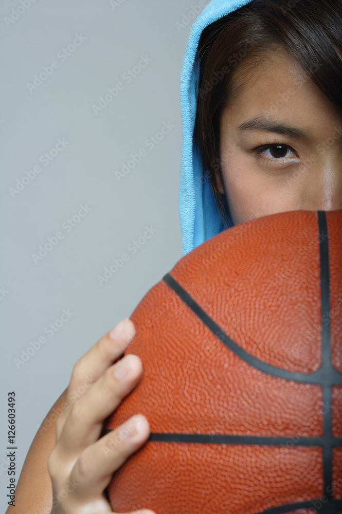 Young woman with basketball looking at camera