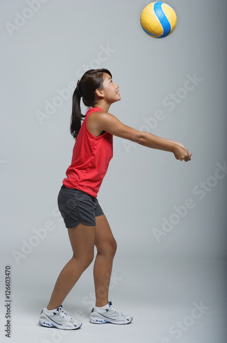 Young woman playing with volleyball