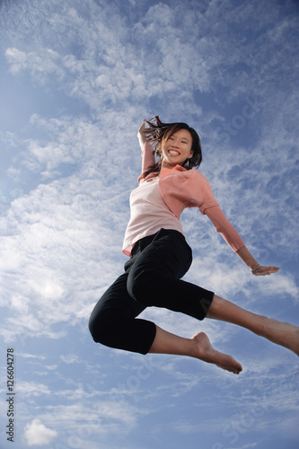 Obraz na płótnie A young woman jumps for joy w salonie