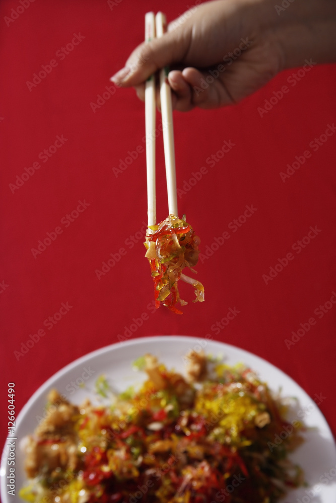 Woman tossing raw fish salad also known as