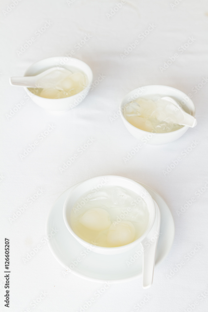 Rambutan in syrup in white cup and saucer on table at restaurant. Rambutan in syrup in white cup and saucer on table at restaurant.