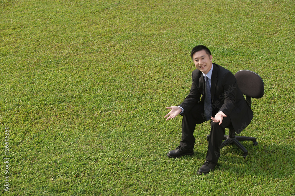 Businessman in office chair, smiling at camera Businessman in office chair, smiling at camera