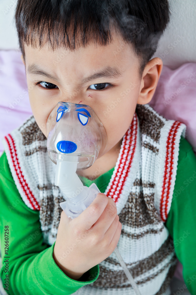 Top view of asian child holds a mask vapor inhaler for treatment