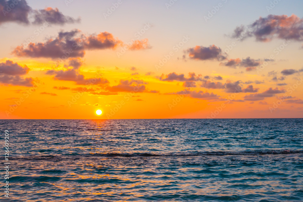 Beautiful sunset with sky over calm sea  in tropical Maldives is