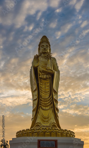 Golden Guanyin statue Buddha with Twilight sky background.