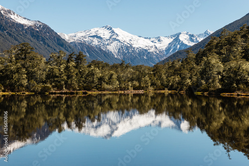 mountain range reflecting in lake in Southern Alps near Lewis Pass, New Zealand photo