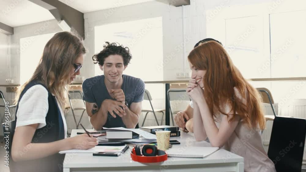 Multiethnic group of happy business people working together while sitting at table in office Multiethnic group of happy business people working together while sitting at table in office