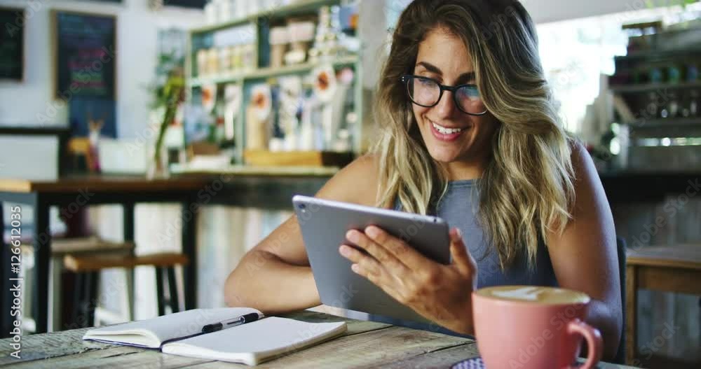 Woman using tablet computer touchscreen in coffee shop