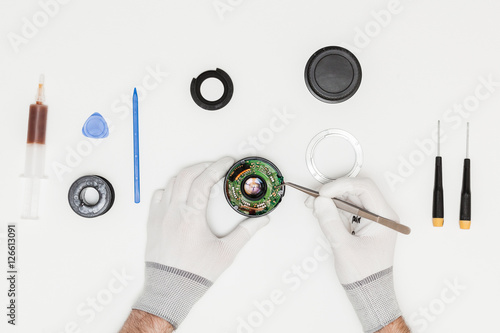 technician repairing broken camera lens, top view, flat lay