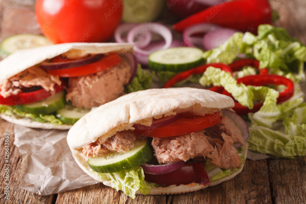 Tasty pita with tuna, cucumber, nappa cabbage, onion and tomatoes closeup. Horizontal Tasty pita with tuna, cucumber, nappa cabbage, onion and tomatoes closeup. Horizontal