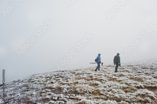 Two tourist photographer with tripod on hand walking on frozen h photo