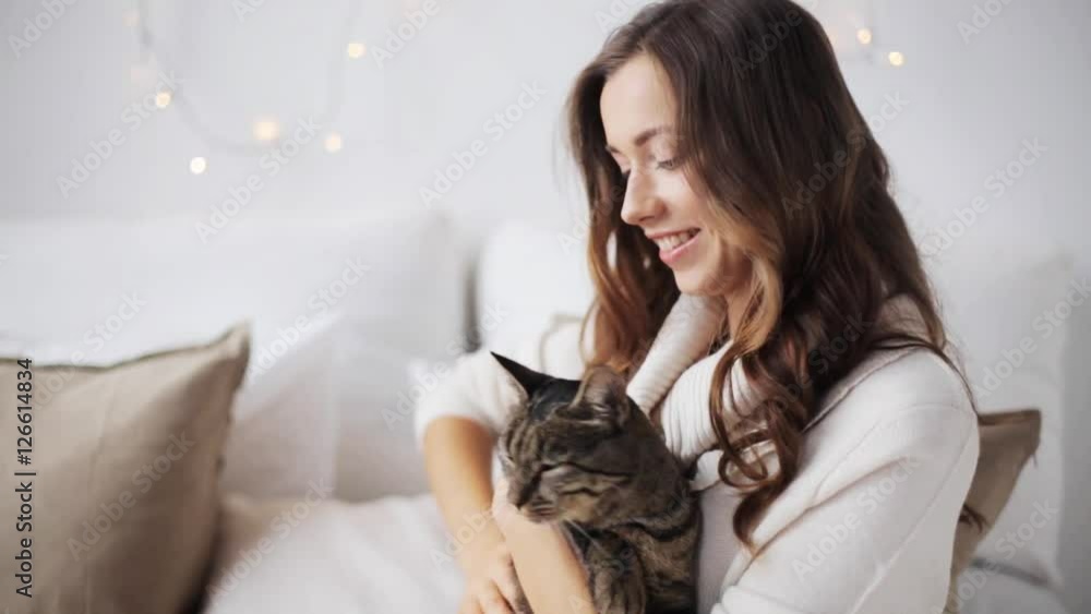 happy young woman with cat in bed at home happy young woman with cat in bed at home