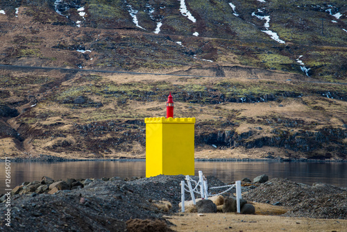 The yellow light house at the fjord of Eskifjordur town of east Iceland. photo