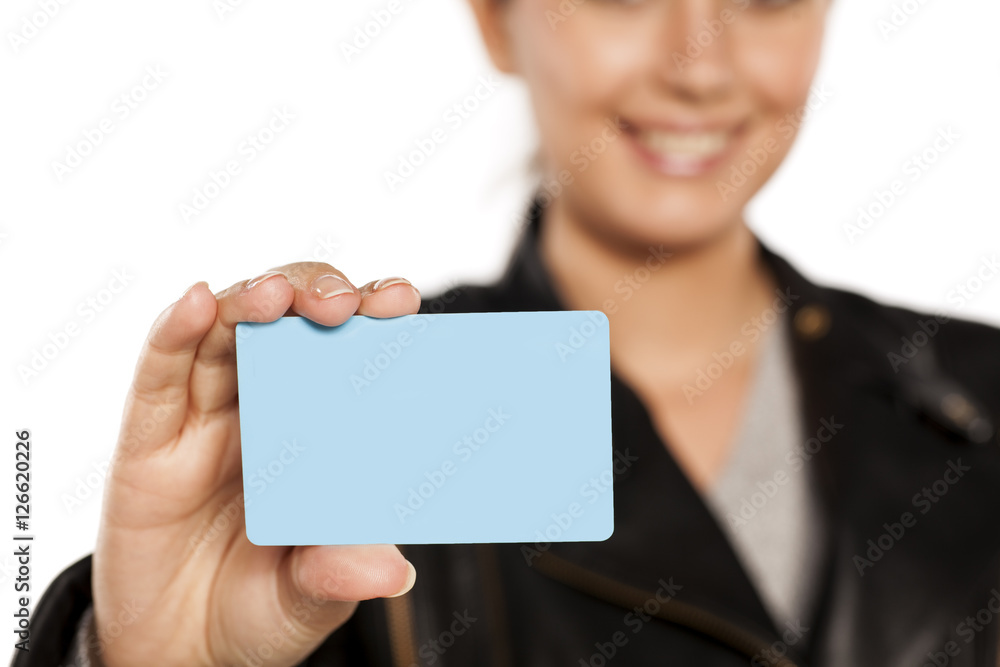 young smiling woman holding a plastic credit card on a white background
