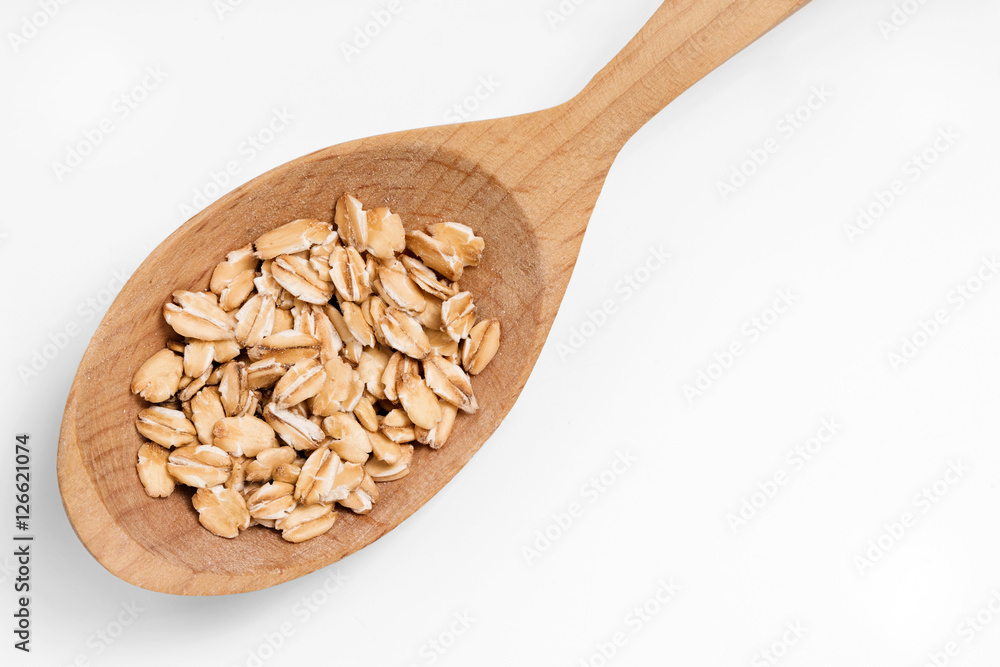 Wooden spoon with oat flakes isolated on white background. Copy space, top view, high resolution product Wooden spoon with oat flakes isolated on white background. Copy space, top view, high resolution product