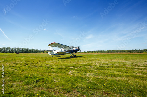 The plane stands on the grass field