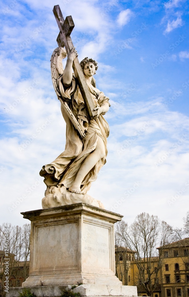 Beautiful angel statue holding the Holy Cross with heavenly sky and copy space, from Sant'Angelo Bridge in the historic center of Rome (17th century) 