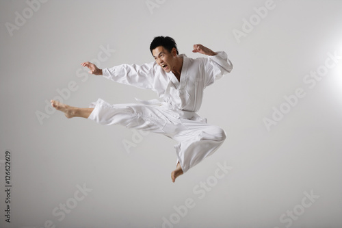 Obraz na płótnie Man doing a flying kick, martial arts w salonie