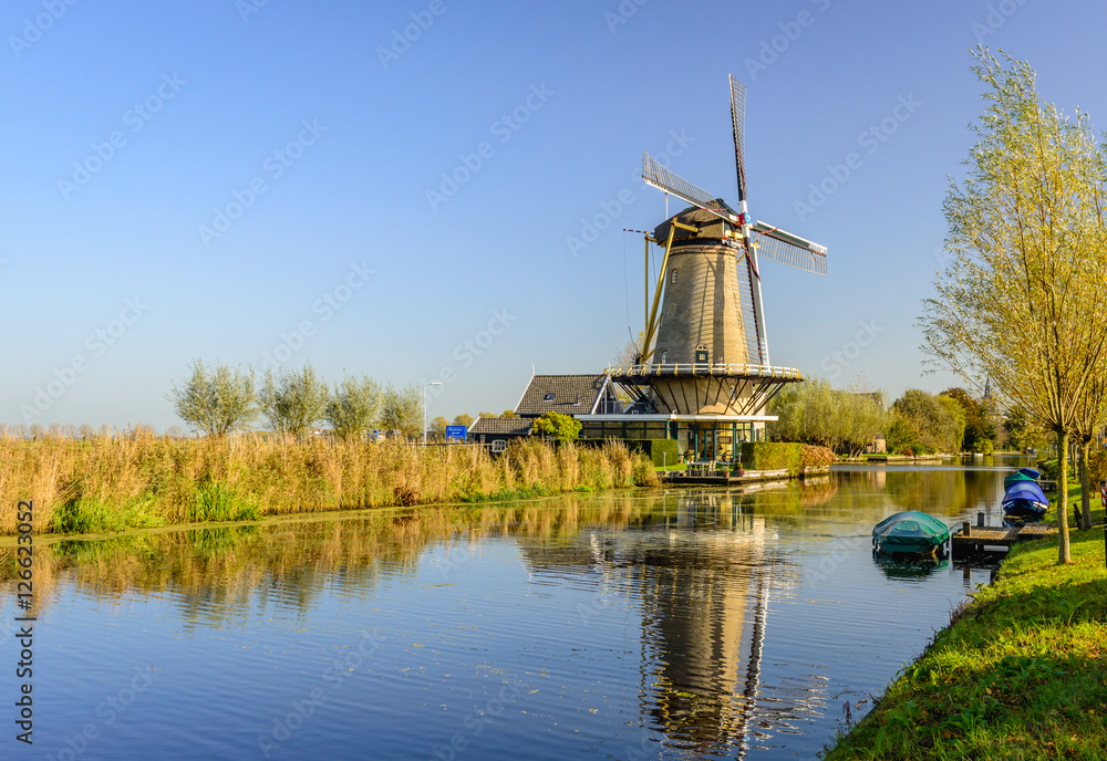 Dutch canal with windmill on a sunny day in autumn