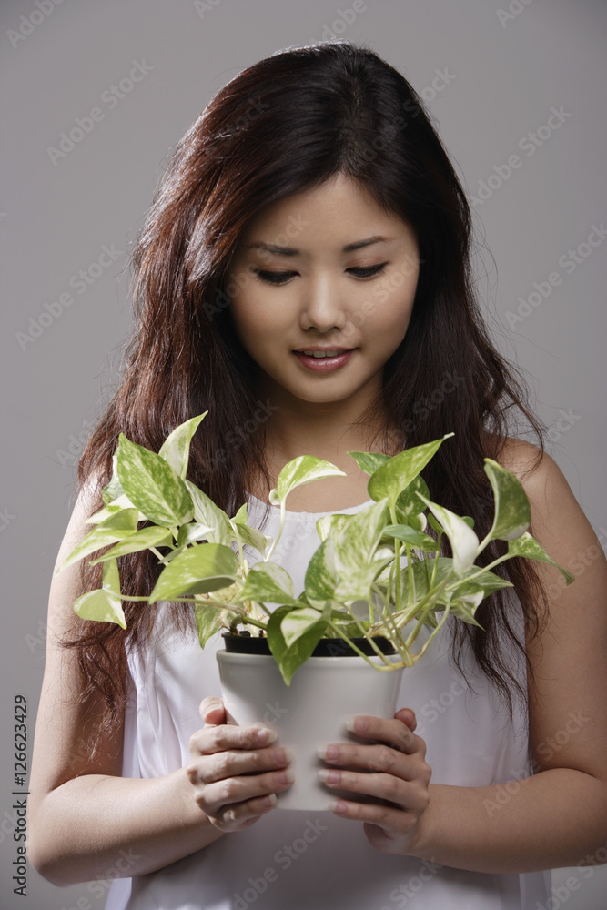 Chinese woman holding green plant Chinese woman holding green plant