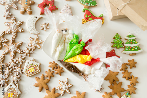 Top view of christmas gingerbread bakes and pastry bags with colorful fillings  glossy sugar cookies. Color sweet Christmas presents concept photo. Small business or Ideas to make fun with kids