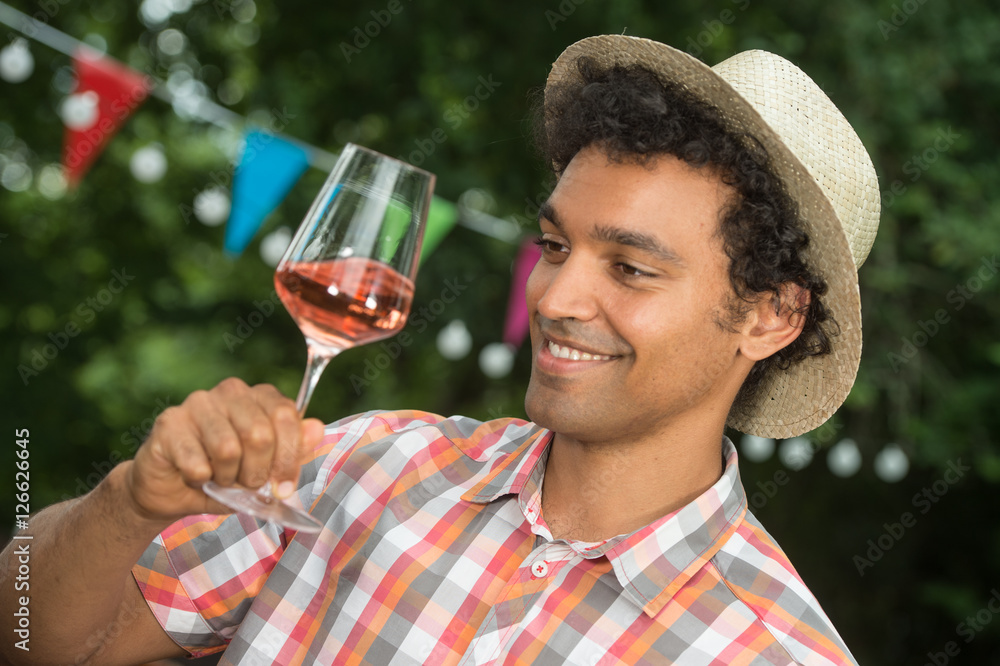 Handsome mature man tasting glass of rose wine Handsome mature man tasting glass of rose wine