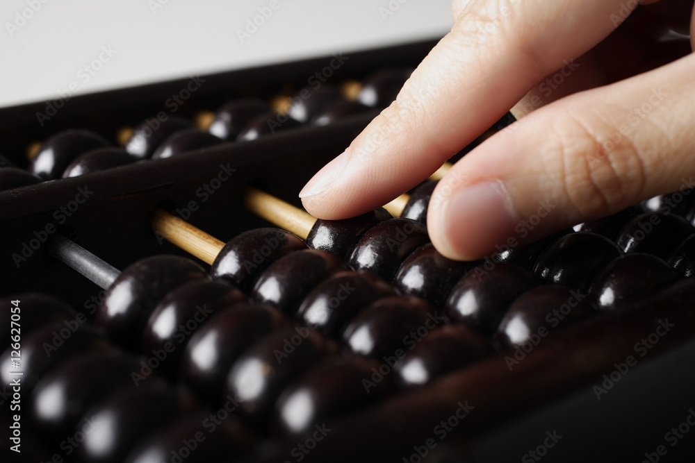 close up of hand touching abacus