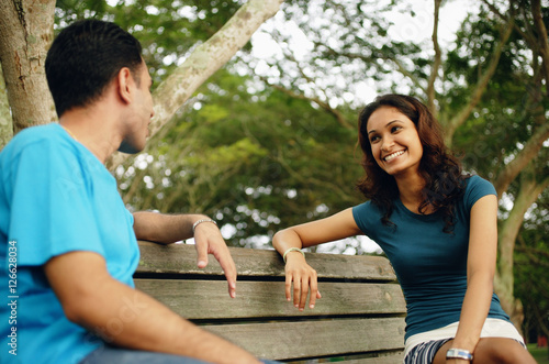 Couple sitting on park bench, talking