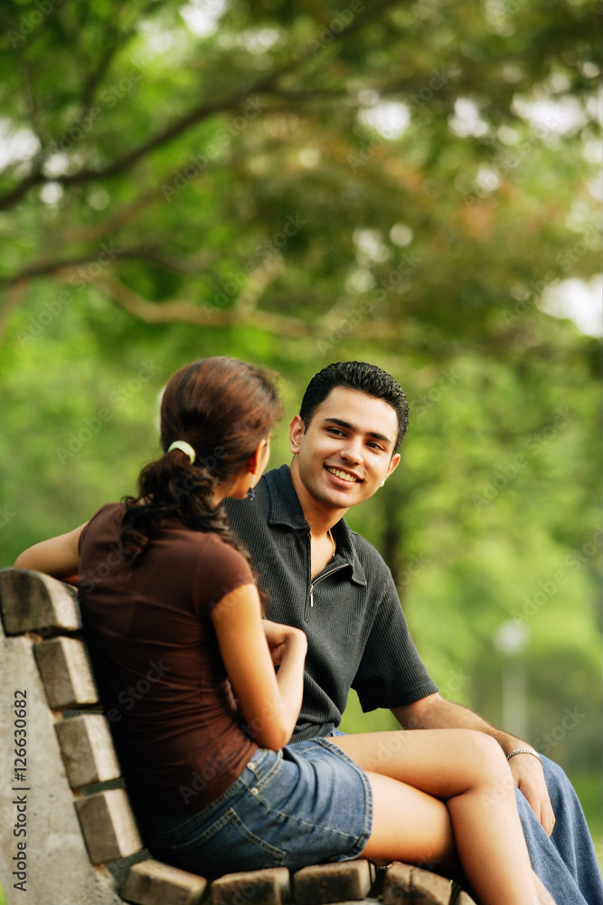 Couple sitting on bench, talking Couple sitting on bench, talking