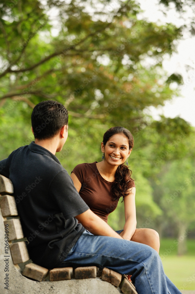 Couple sitting and talking on bench Couple sitting and talking on bench