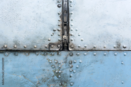 Old blue and silver metal surface of the aircraft fuselage with rivets © watman