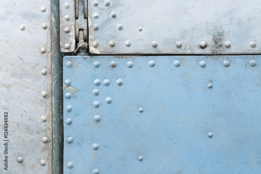 Old blue and silver metal surface of the aircraft fuselage with rivets Old blue and silver metal surface of the aircraft fuselage with rivets