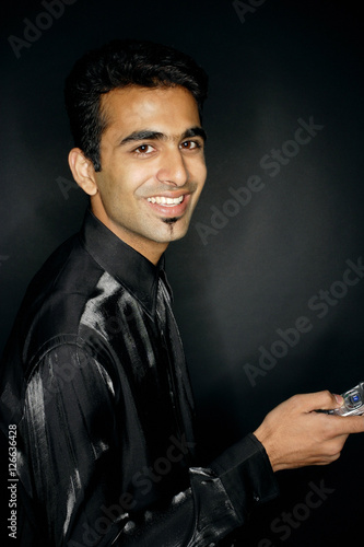 Man looking at camera, holding mobile phone