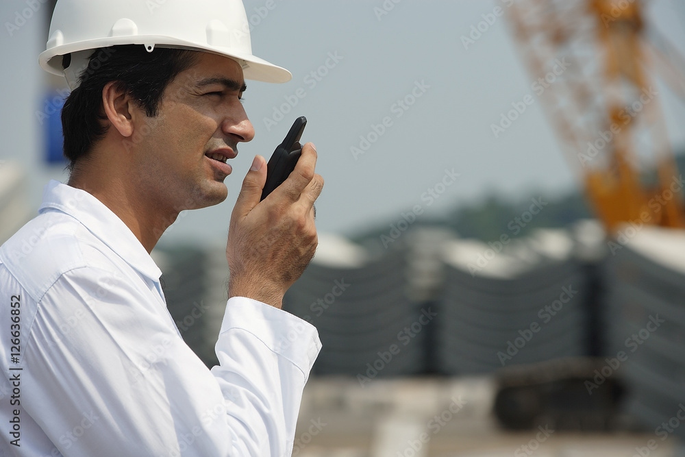 Man in work uniform, talking into walkie talkie