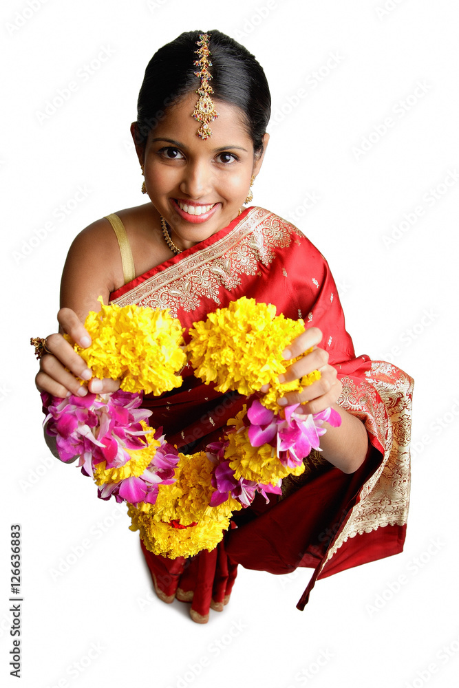 Woman in sari, holding flower garland, smiling Woman in sari, holding flower garland, smiling