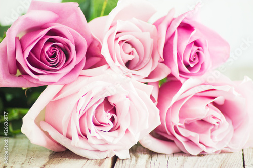 Blurred pink roses on wooden background