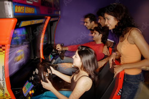 Young adults playing games in amusement arcade