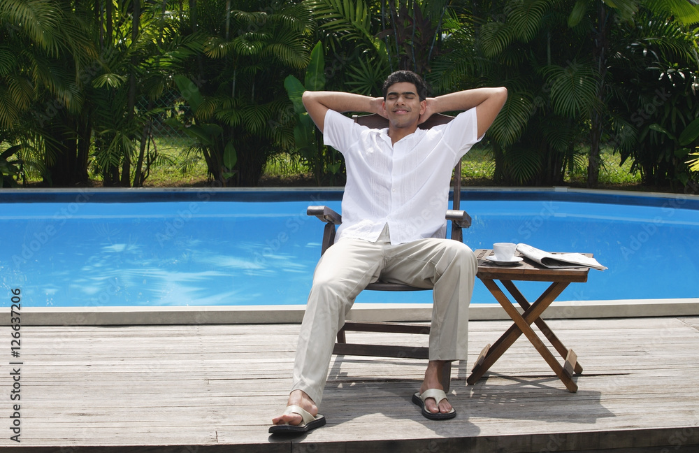 Man relaxing in chair by the pool